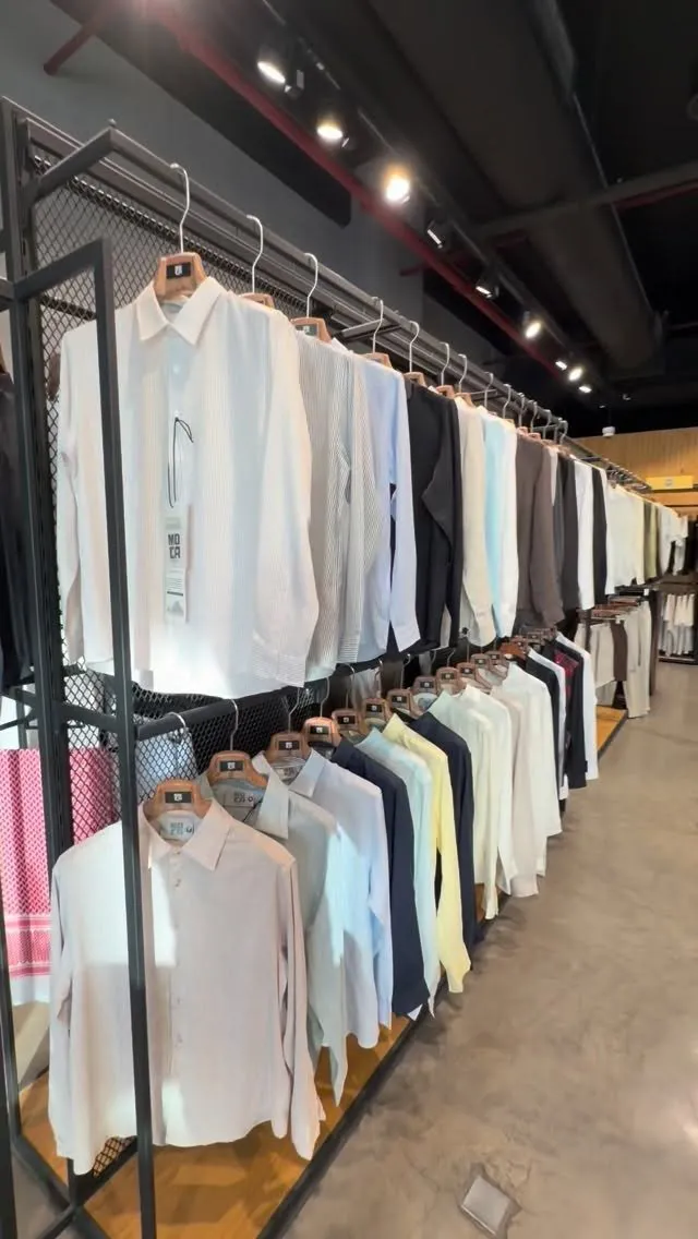 A long rail of shirts sorted by colour in the Fashion Corner store
